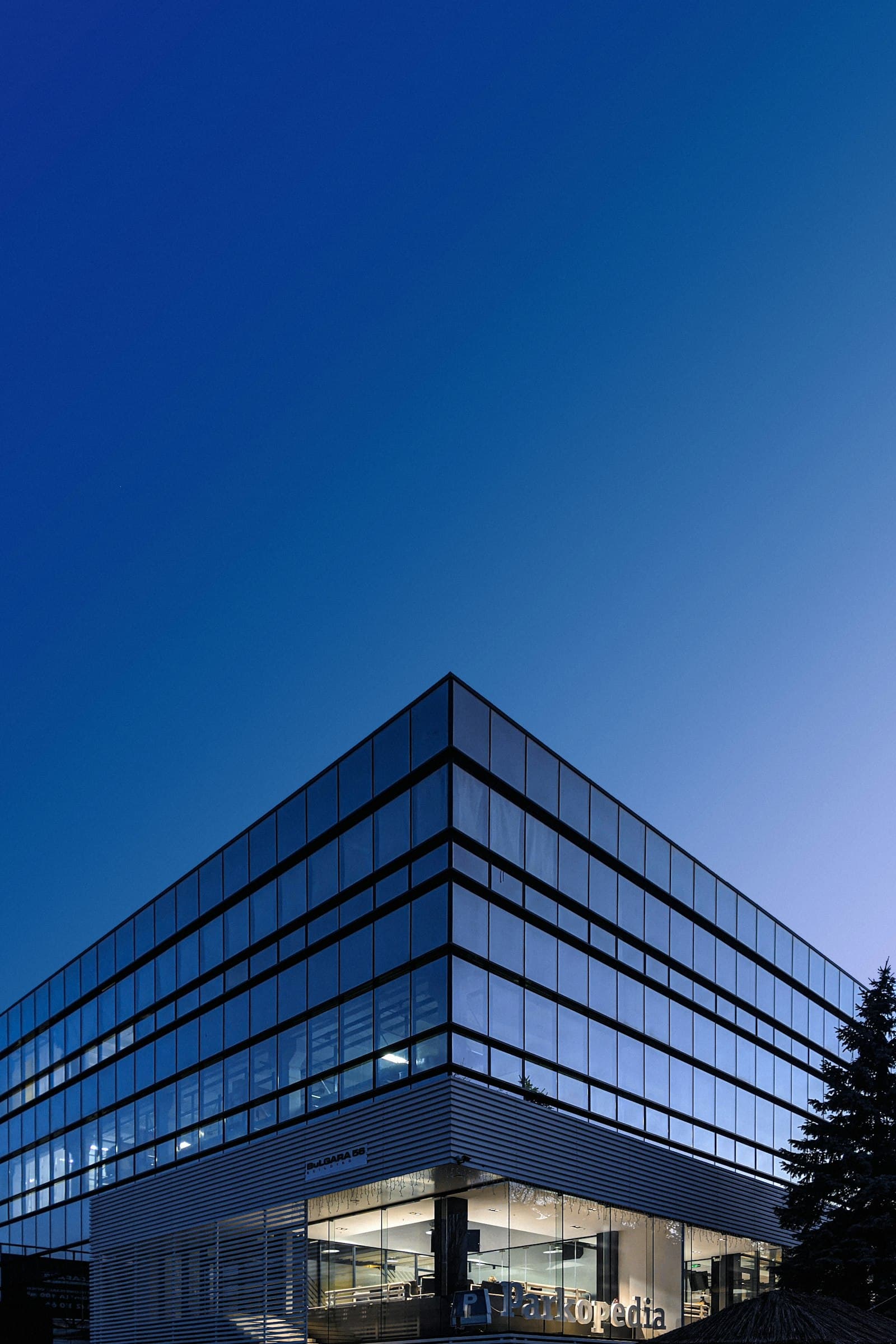 Modern glass office building against a blue sky